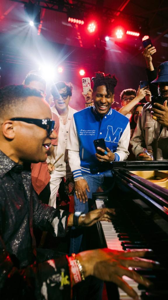 Musicians gathered around a grand piano during a live jam session