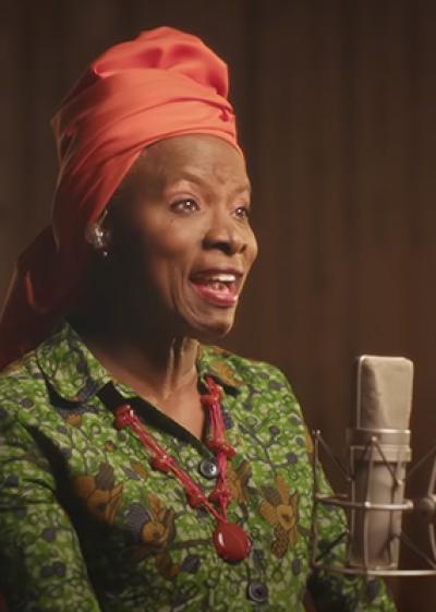 image of Angelique in front of a microphone performing 